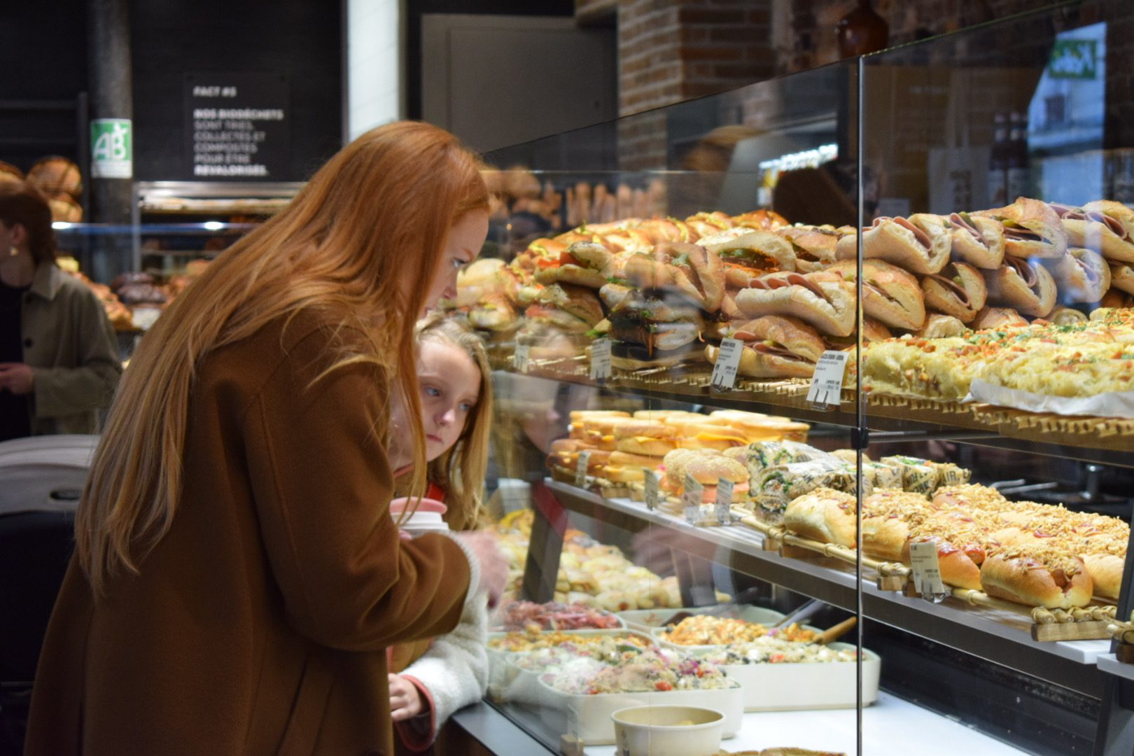 Private Marais Food Tour | Authentic Paris Culinary Walking Experience with Expert Guide Private Marais Food Tour Paris - mother and child at artisan bakery discovering French pastries with Paris and Beyond Tours.