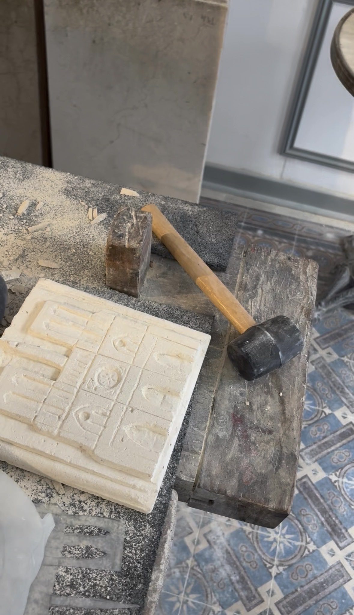 Medieval Stone Carving Details – Paris Workshop Carved stone tile, wooden mallet and tools resting on a dusty workbench during a medieval-style stone cutting workshop in Paris