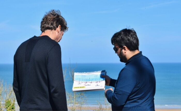 Paris and Beyond Tours guide explaining Omaha Beach D-Day tactical map to guest overlooking landing sectors - private WWII history tour from Bayeux Caen