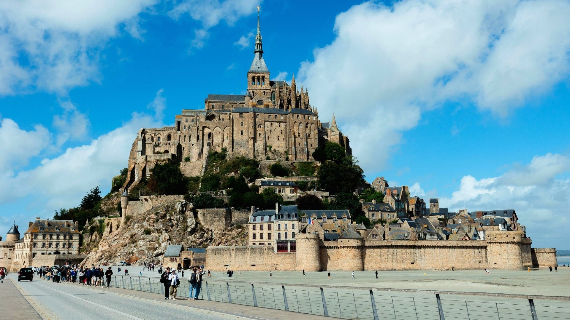 Mont Saint-Michel Full View Low Tide Blue Sky Perfect Day Paris Beyond Tours Mont Saint-Michel full view low tide blue sky visitors causeway - Paris and Beyond Tours private day trip from Bayeux Caen