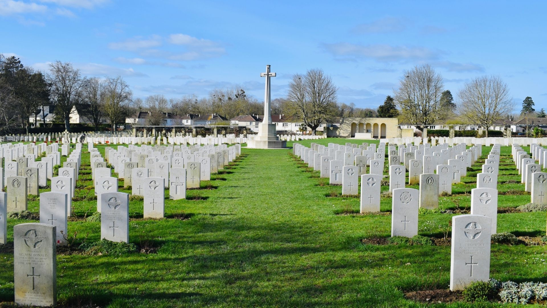 Bény-sur-Mer Cross of Sacrifice Cemetery View Paris Beyond Normandy D-Day Tour Bény-sur-Mer Canadian War Cemetery Cross of Sacrifice central view white headstones rows chapel Norman village - Paris Beyond Tours