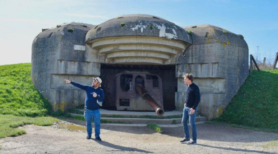 Paris and Beyond Tours guide explaining Longues-sur-Mer German battery casemate exterior 150mm cannon - private D-Day tour from Bayeux Caen